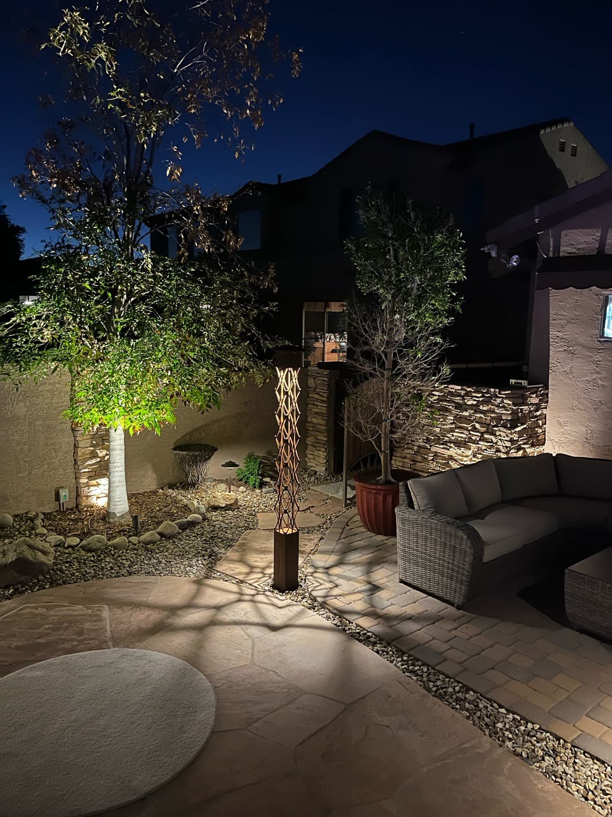 Backyard patio at night lit by Kredit accent lighting