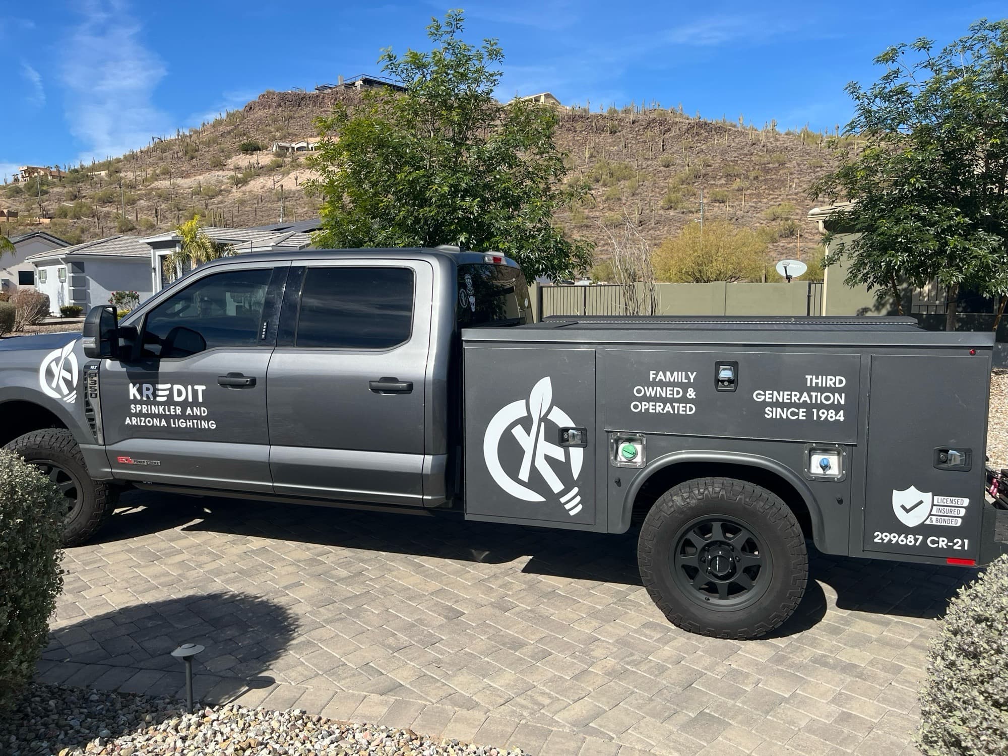 Kredit Sprinkler & Arizona Lighting service truck parked in front of a Phoenix hillside